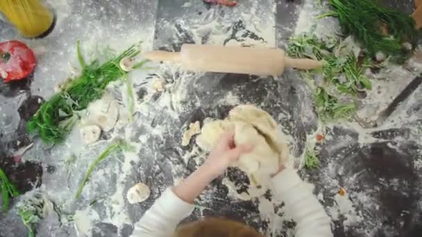 Mały chłopiec próbuje zrobić pizzę w przygotowaniu przez siebie w bałaganie, z góry widzenia. — Wideo stockowe