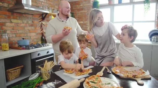 Glad leende familj äter läcker hemlagad pizza hemma kök. — Stockvideo