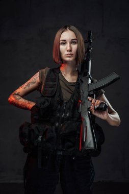 Tüfekli, esmer, çekici bir kadın.