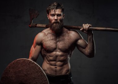 Kalkanları ve baltaları koyu arkaplanda duran bir yağmacı.