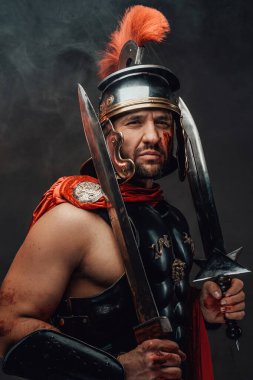 Roma şampiyonu karanlık arka planda kılıçlarla poz veriyor