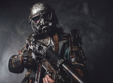 Özel zırhlı ve silahlı takipçi koyu arkaplanda poz veriyor