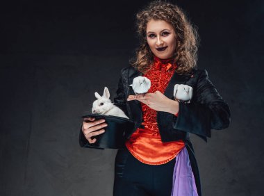 Beyaz bir kadın, büyüleyici bir tavşan ve arka planda güvercinler.