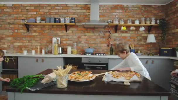 L'adorabile grande famiglia corre nella cornice e inizia a mangiare pizza in cucina. — Video Stock