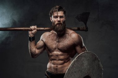 Siyah duman arka planında balta ve kalkan ile kaslı viking