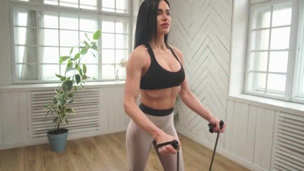 Крупным планом женщина стоит, тренирует мышцы спины и руки во время карантина. — стоковое видео