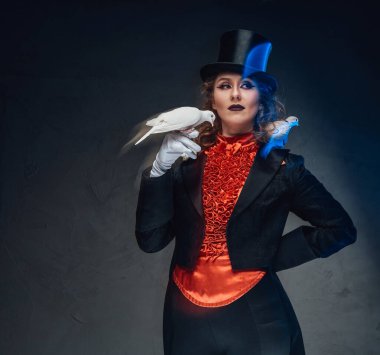 Sirkteki çekici kadın sihirbaz stüdyoda güvercinlerle poz veriyor.