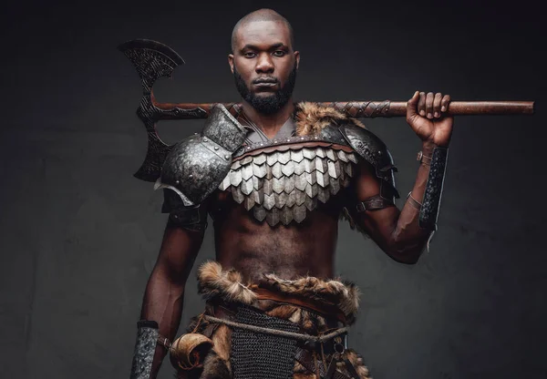 Soldado heróico e selvagem em armadura de aço com machado nos ombros — Fotografia de Stock