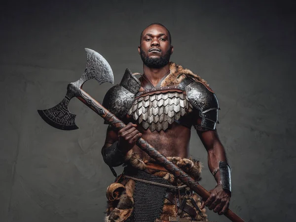 Africano viking furioso em armadura antiga segurando um enorme machado de aço — Fotografia de Stock