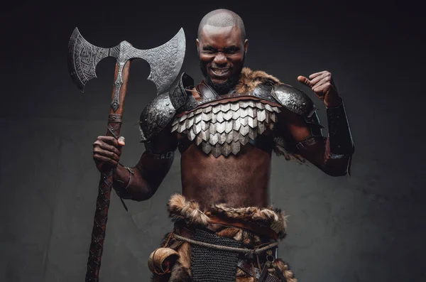 Evil barbaric man with black skin and axe in dark background — Stock Photo, Image