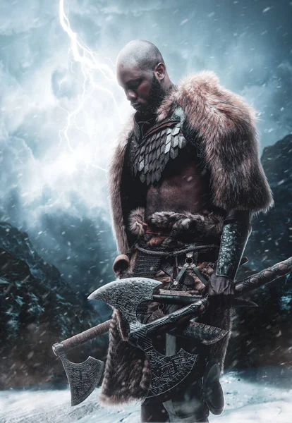Ontevreden viking met zwarte huid met bijlen in stormachtige bergen — Stockfoto