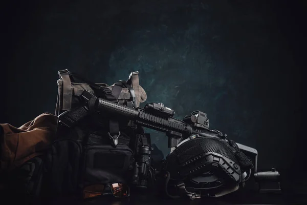 Militante Ausrüstung und Waffen auf einem Tisch vor dunklem Hintergrund — Stockfoto