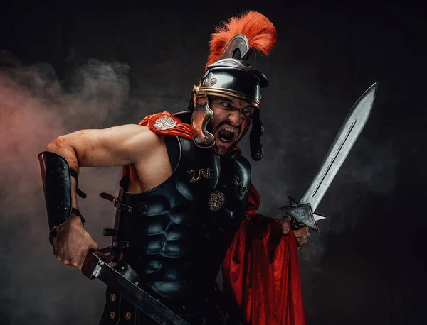 Screaming and savage roman warrior with swords and armour — Stock Photo, Image