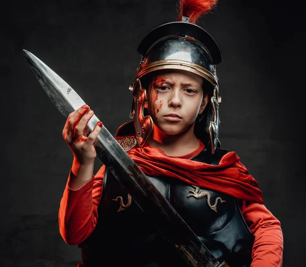 Pequeño soldado romano enojado con espada en el fondo oscuro — Foto de Stock