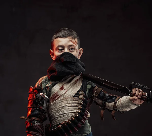 Young boy with blade on his shoulder in dark background — Stock Photo, Image