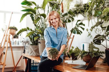 Masada oturan dikkatli genç bir kadının portresi.