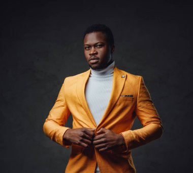 Afrika kökenli zarif iş adamı ceketini ilikliyor.