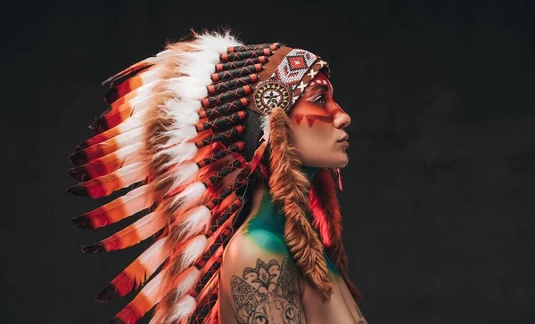 Tetovált trendi nő, tollas nemzeti fejfedőt visel — Stock Fotó