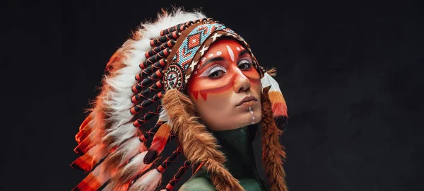 Törzsi női harcos fejfedővel tollakból sötét háttérrel — Stock Fotó
