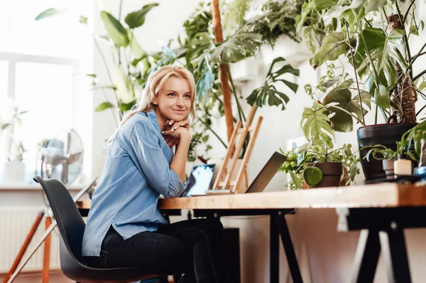 Satisfeita mulher de negócios bonita com um laptop sentado à mesa — Fotografia de Stock