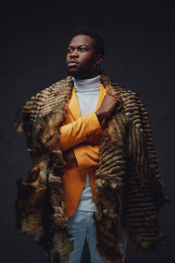 Koyu arkaplanda kürklü şık siyah hipster.