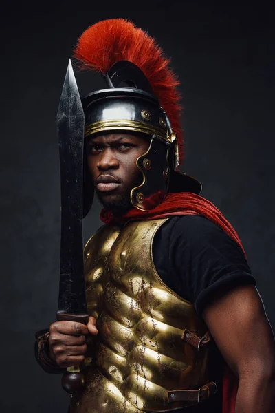 Preto soldado romano posa contra fundo escuro — Fotografia de Stock