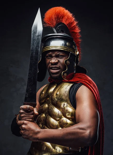 Wściekły rzymski żołnierz z mieczem na ciemnym tle — Zdjęcie stockowe