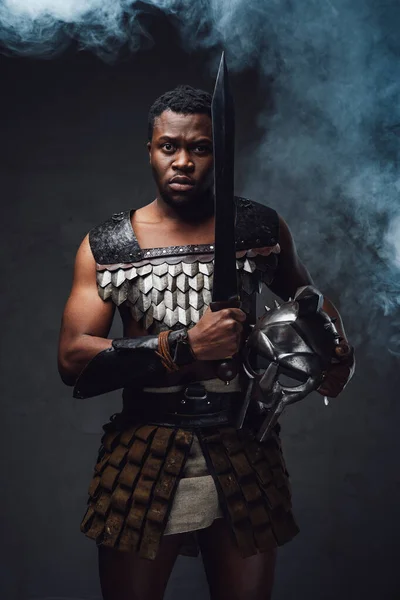 Studio shot van angstige authentieke gladiator van Afrikaanse afkomst met gladius — Stockfoto