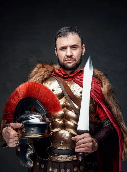 Imperial soldier holding helmet and short sword — Stock Photo, Image