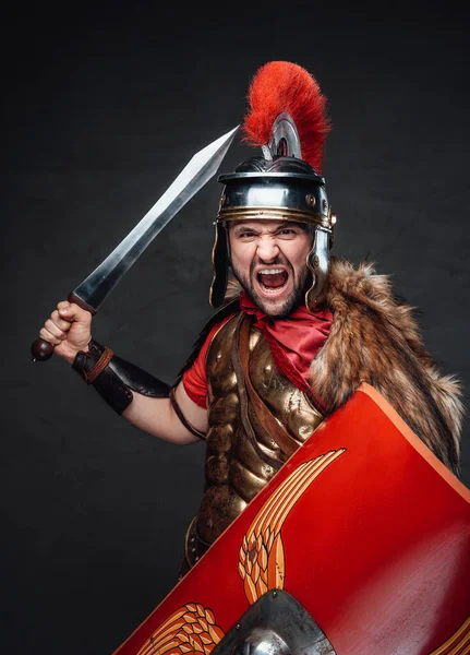 Violento soldado romano grita contra fundo escuro — Fotografia de Stock
