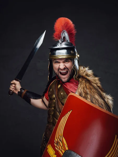 Violent roman soldier screams against dark background — Stock Photo, Image