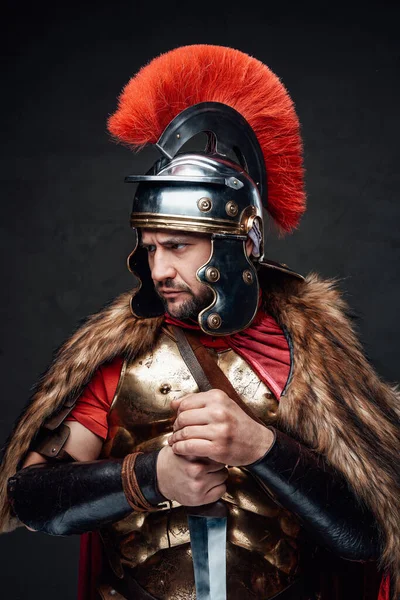 Boze oude Romeinse soldaat tegen donkere achtergrond — Stockfoto