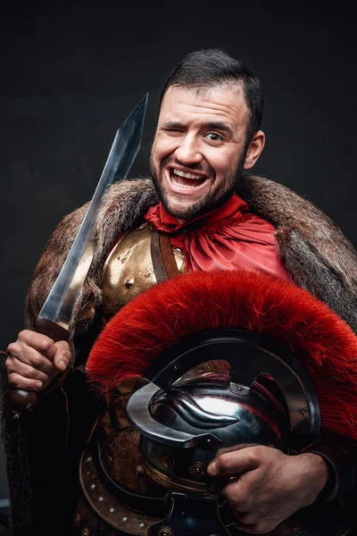 Imperador romano engraçado segurando espada e capacete — Fotografia de Stock