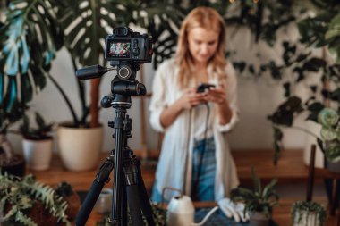 Bahçede kameralı akıllı telefondan konuşan kadın blogcu