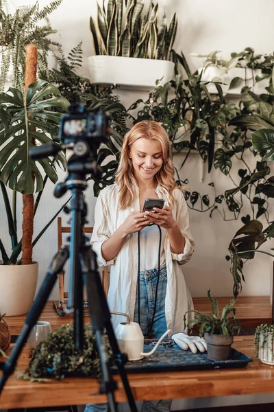 Narablog perempuan dengan chatting di smartphone di taman dengan kamera — Stok Foto