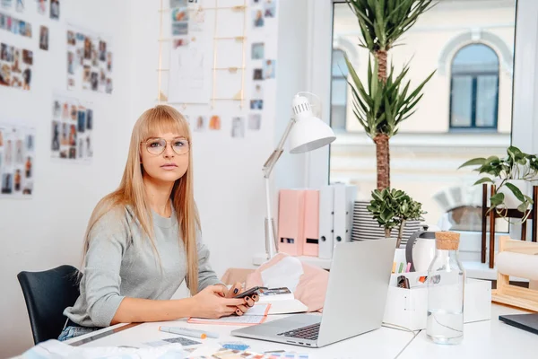 Mulher de negócios caucasiana com celular e laptop no escritório — Fotografia de Stock