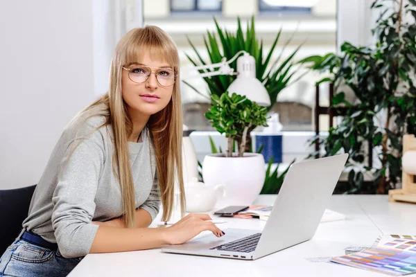 Jovem mulher usando dispositivos de escritório modernos e trabalhando durante o dia — Fotografia de Stock