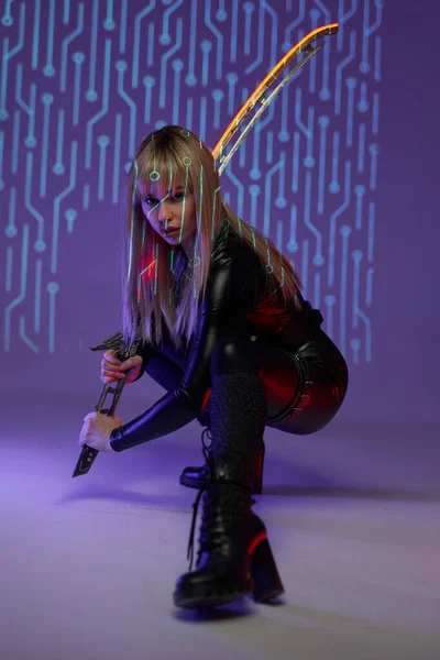 輝く剣を持つサイバーパンクスタイルの女性暗殺者 — ストック写真