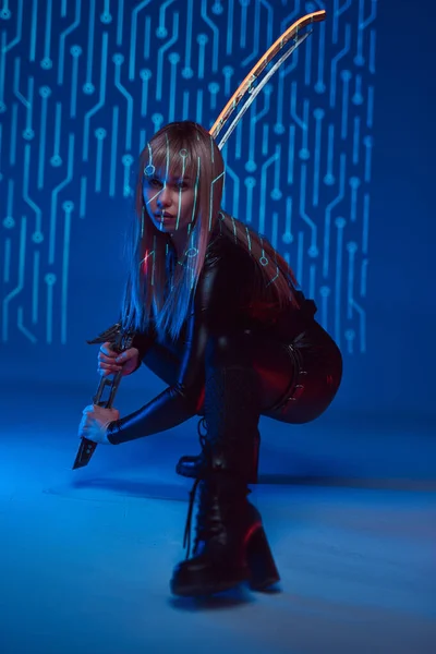 Cyberpunk mulher estilo assassino com espada brilhante — Fotografia de Stock