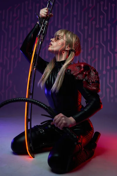 Mulher Cyberpunk assassina sentada no chão com espada — Fotografia de Stock
