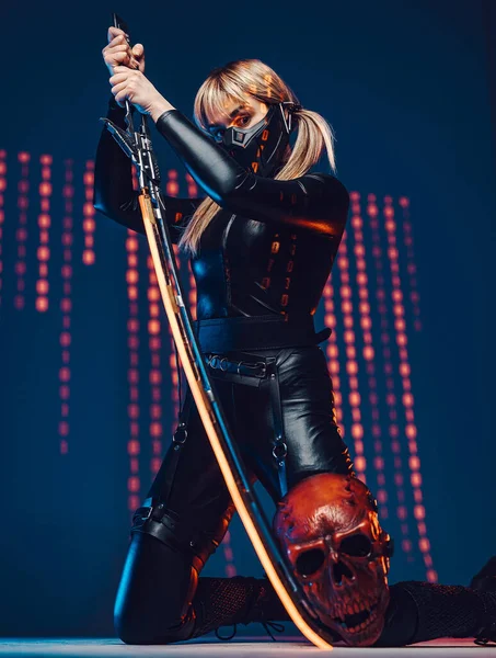 Woman assassin with sword against colourful background — Stock Photo, Image