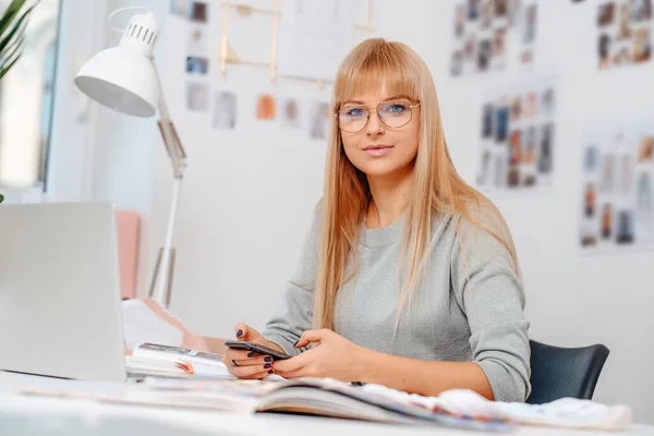 Happy businesswoman z telefonem komórkowym i laptopem w biurze — Zdjęcie stockowe