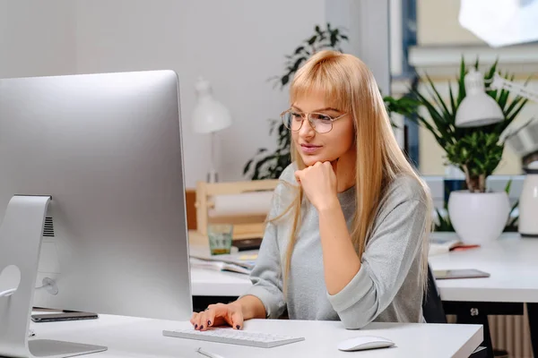 Vrolijke zakenvrouw bril en desktop computer in kantoor kamer — Stockfoto