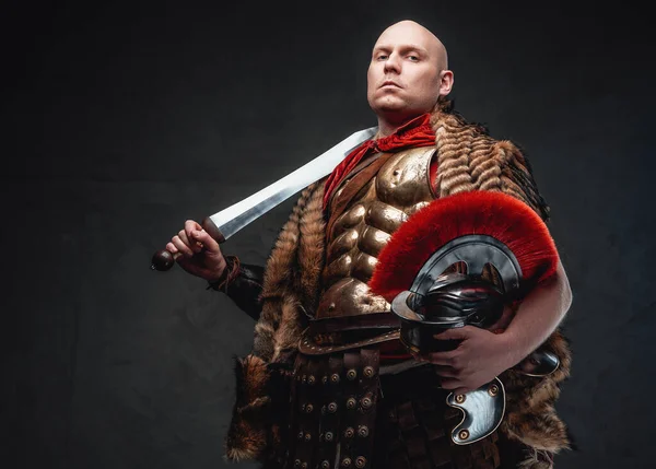 Legionário careca com capacete de pele segurando com espada — Fotografia de Stock