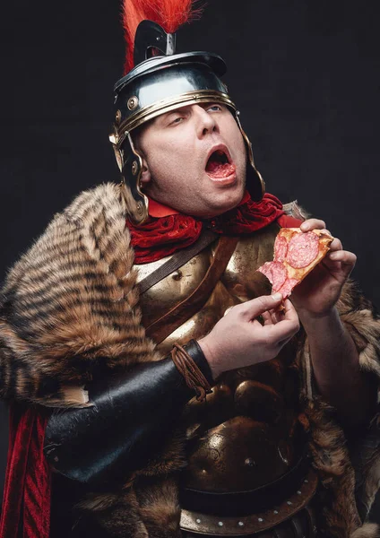 Веселий римський легіонер зі скибочкою піци — стокове фото