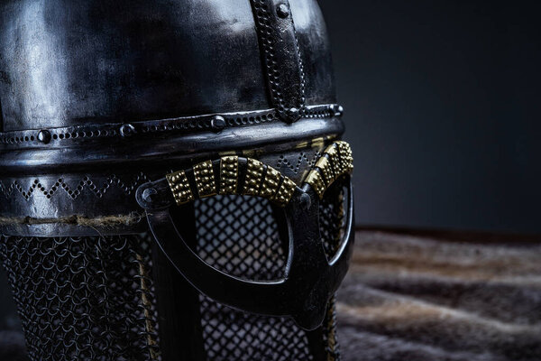 Medieval protective headwear of knight with chainmail against dark background.