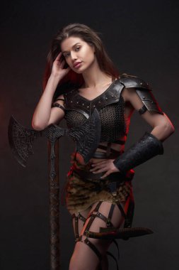 Elinde baltayla gezen vahşi bir kadının stüdyo fotoğrafı.