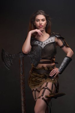 Elleri çenesinin altında gezen barbar bir kadın.