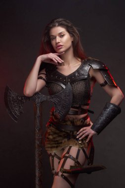 Elleri çenesinin altında gezen barbar bir kadın.