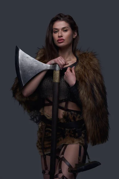 Northern valkyrie wearing fur coat and holding axe — Stock Photo, Image